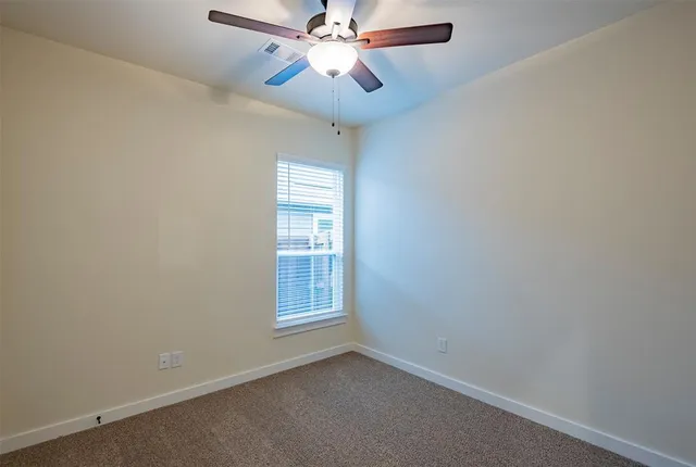 a view of a room with a ceiling fan and a ceiling fan