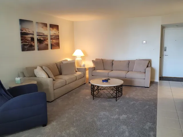 a living room with furniture a lamp and a window