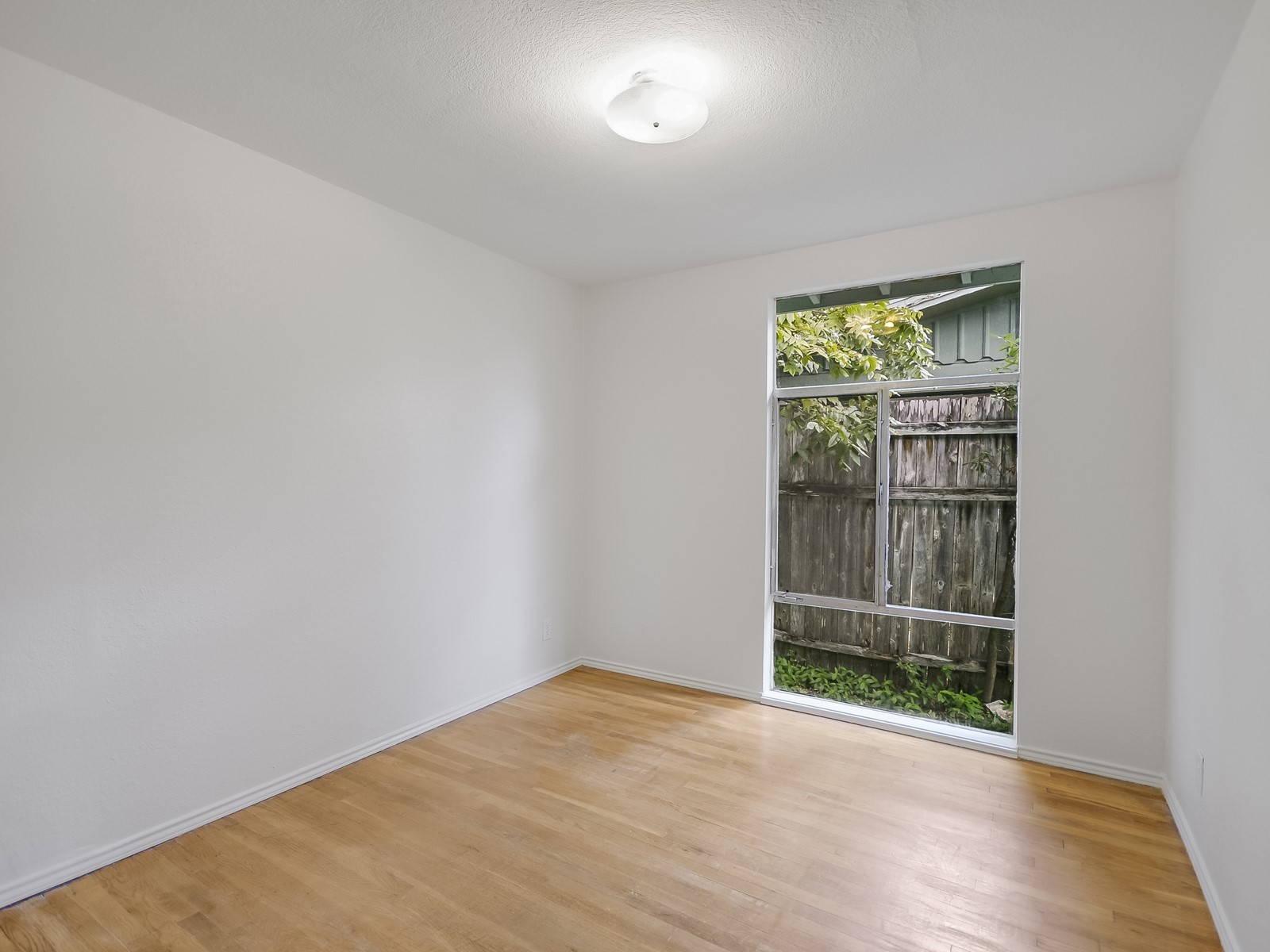 112 East Skyview Road Austin, TX 78752 - Photo 8 of 10 an empty room with wooden floor and windows