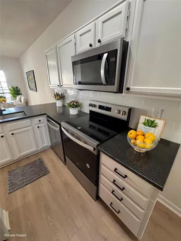 a kitchen with stainless steel appliances granite countertop a stove and a microwave