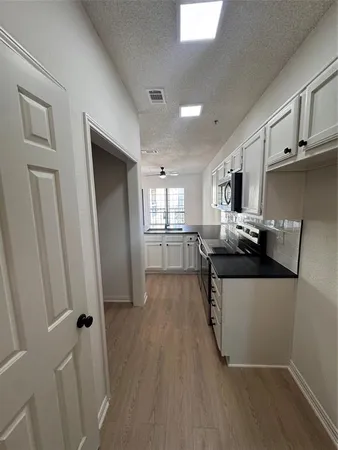a kitchen with granite countertop a refrigerator and a stove top oven
