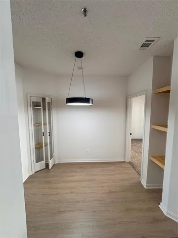 a view of empty room with wooden floor and window