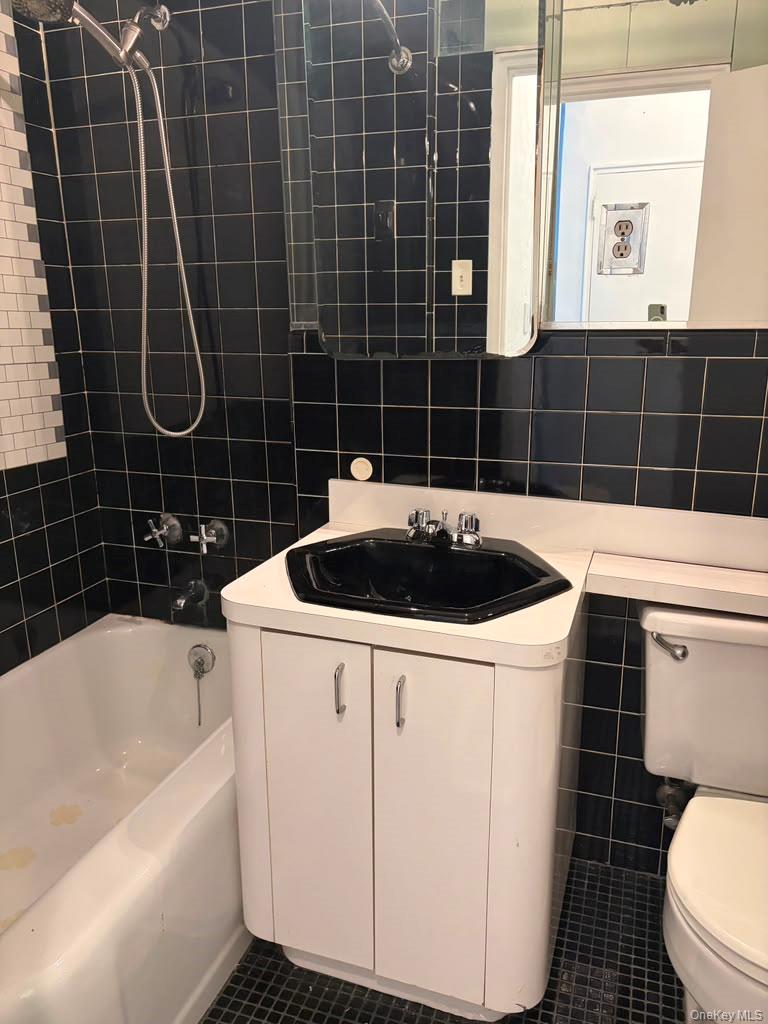 99-60 63rd Road, Unit 1H Queens, NY 11374 - Photo 5 of 11 a bathroom with a sink a toilet a mirror and a bathtub