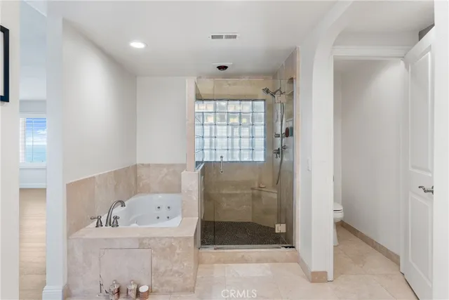 a spacious en suite bathroom with a toilet a sink and a mirror