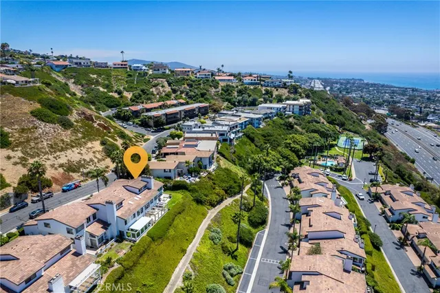 an aerial view of residential houses with outdoor space and trees