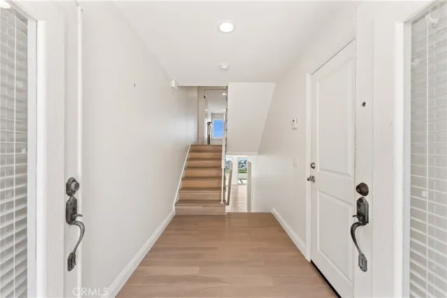 a view of a hallway with wooden floor and staircase