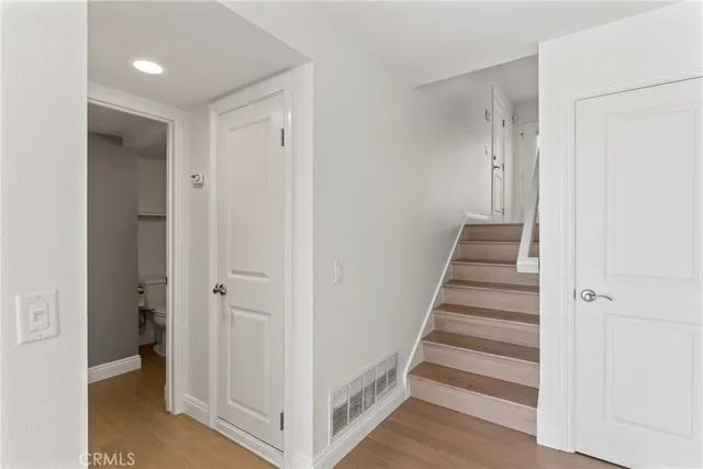 a view of a livingroom with wooden floor and staircase