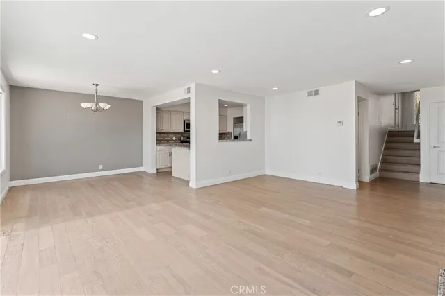 a view of an empty room with wooden floor and closet