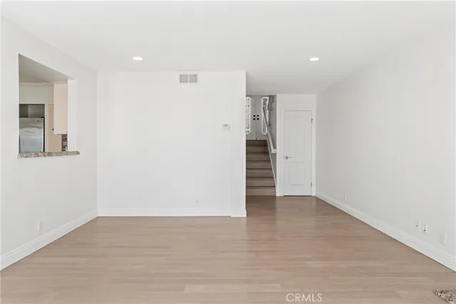 wooden floor fireplace and windows in an empty room
