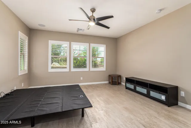a living room with hard wood floors and a ceiling fan