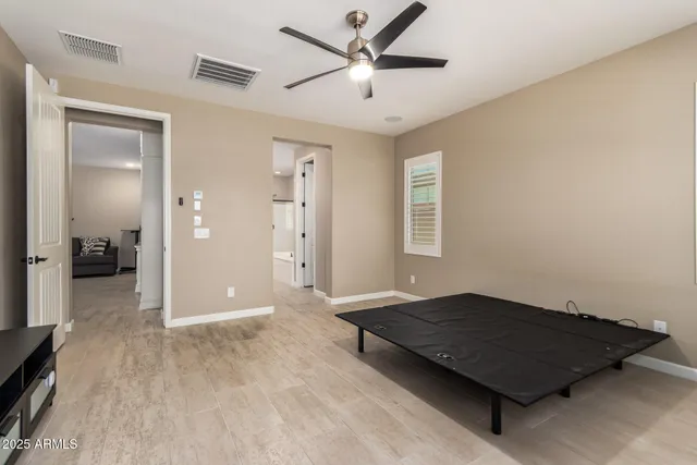 a living room with a bed and a ceiling fan