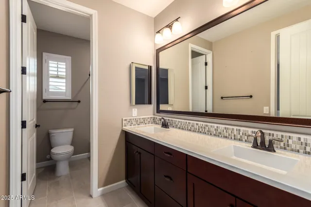 a bathroom with a double vanity sink and a mirror
