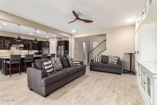 a living room with furniture kitchen view and a chandelier