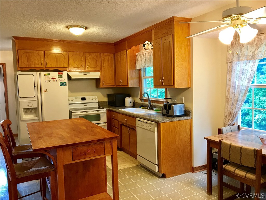 5409 Takach Road Prince George, VA 23875 - Photo 12 of 26 a kitchen with stainless steel appliances kitchen island granite countertop a table chairs and a refrigerator