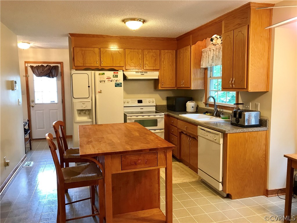 5409 Takach Road Prince George, VA 23875 - Photo 13 of 26 a kitchen with a stove a sink a dining table and chairs