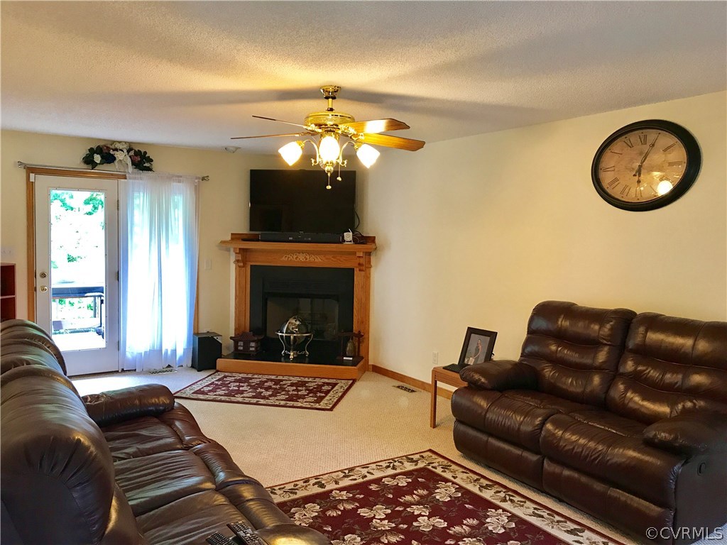 5409 Takach Road Prince George, VA 23875 - Photo 9 of 26 a living room with furniture a fireplace and a flat screen tv