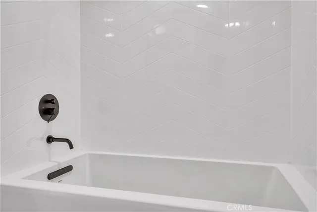 an empty room with wooden floor cabinet and windows