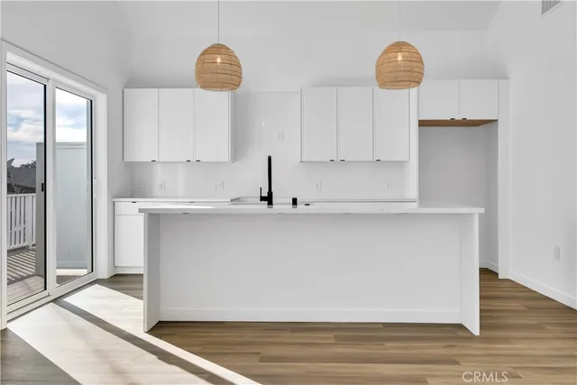 a kitchen with a sink cabinets and wooden floor