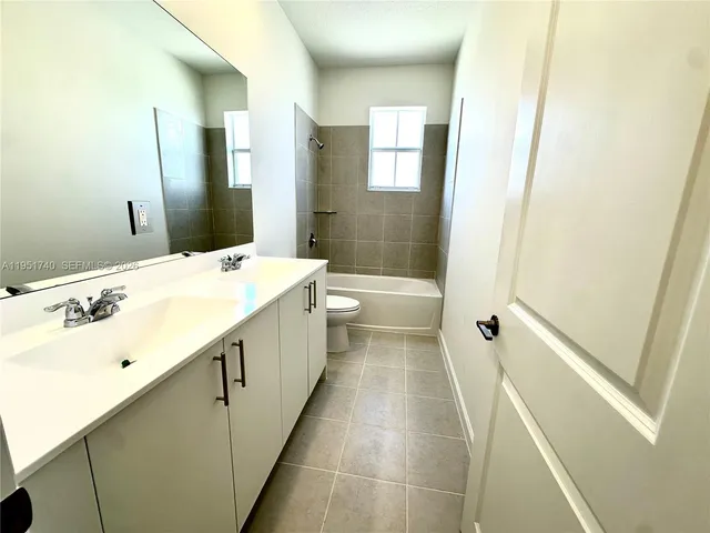 a bathroom with a tub sink and a mirror