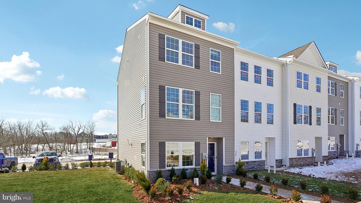a front view of a building with lot of trees around it