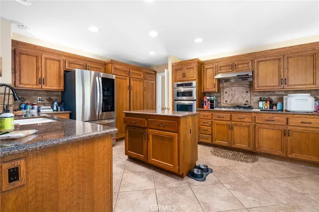 a kitchen with stainless steel appliances granite countertop a refrigerator and cabinets