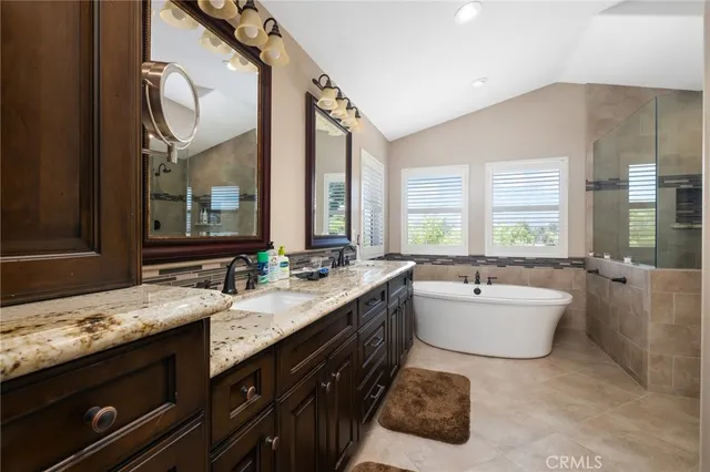 a spacious bathroom with a tub sink and mirror
