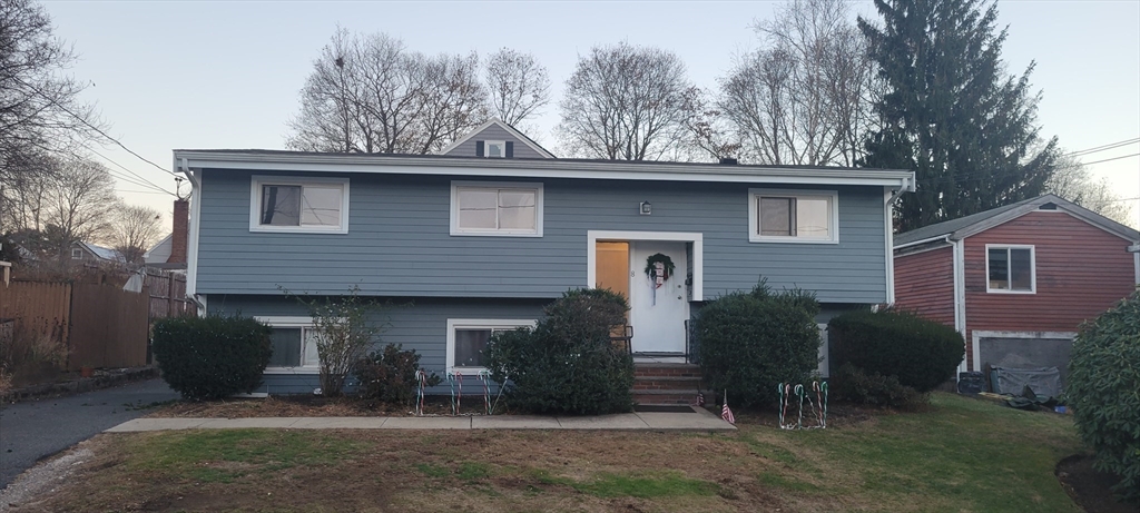 a front view of a house with a garden and plants