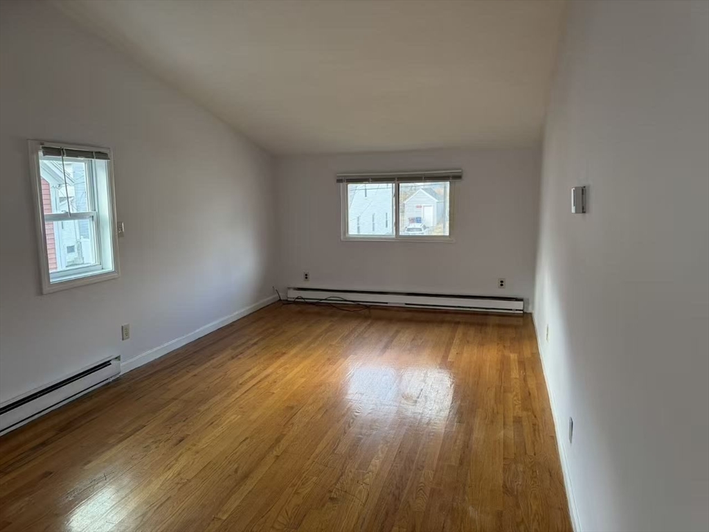 8 Glen Avenue, Unit 2 Melrose, MA 02176 - Photo 3 of 14 an empty room with wooden floor and windows
