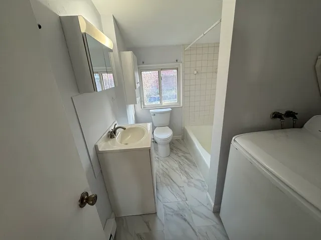 a bathroom with a sink and mirror with bathtub