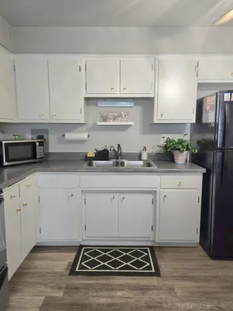 a kitchen with granite countertop a stove and white cabinets