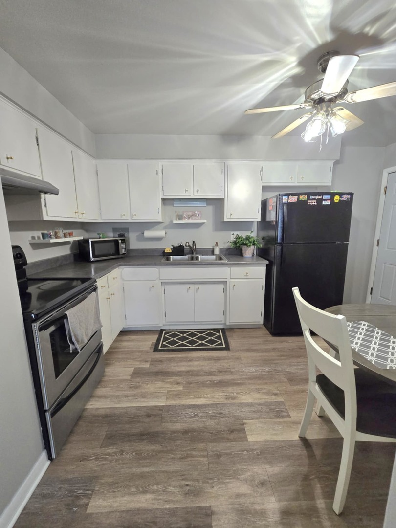 1101 Harlem Avenue, Unit 203 Oak Park, IL 60130 - Photo 13 of 58 a kitchen with stainless steel appliances granite countertop a stove top oven a sink a dining table and chairs with white cabinets