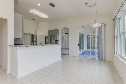 a view of a kitchen with refrigerator and windows