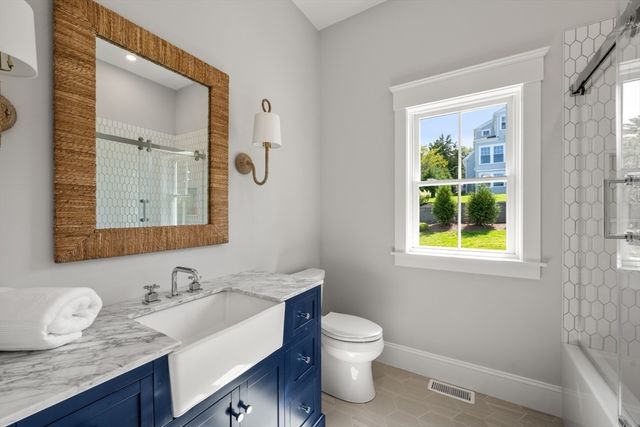 a bathroom with a granite countertop sink toilet and mirror