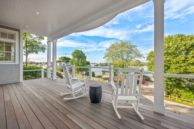a view of a balcony with chairs and wooden floor