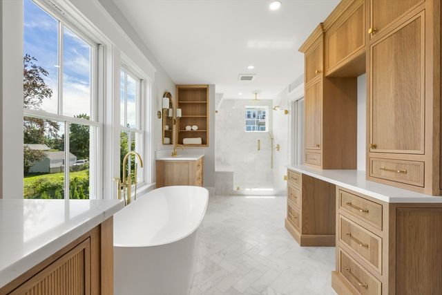 a bathroom with a tub sink vanity and mirror