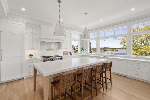 a kitchen with stainless steel appliances granite countertop a stove a sink a refrigerator a center island and a window