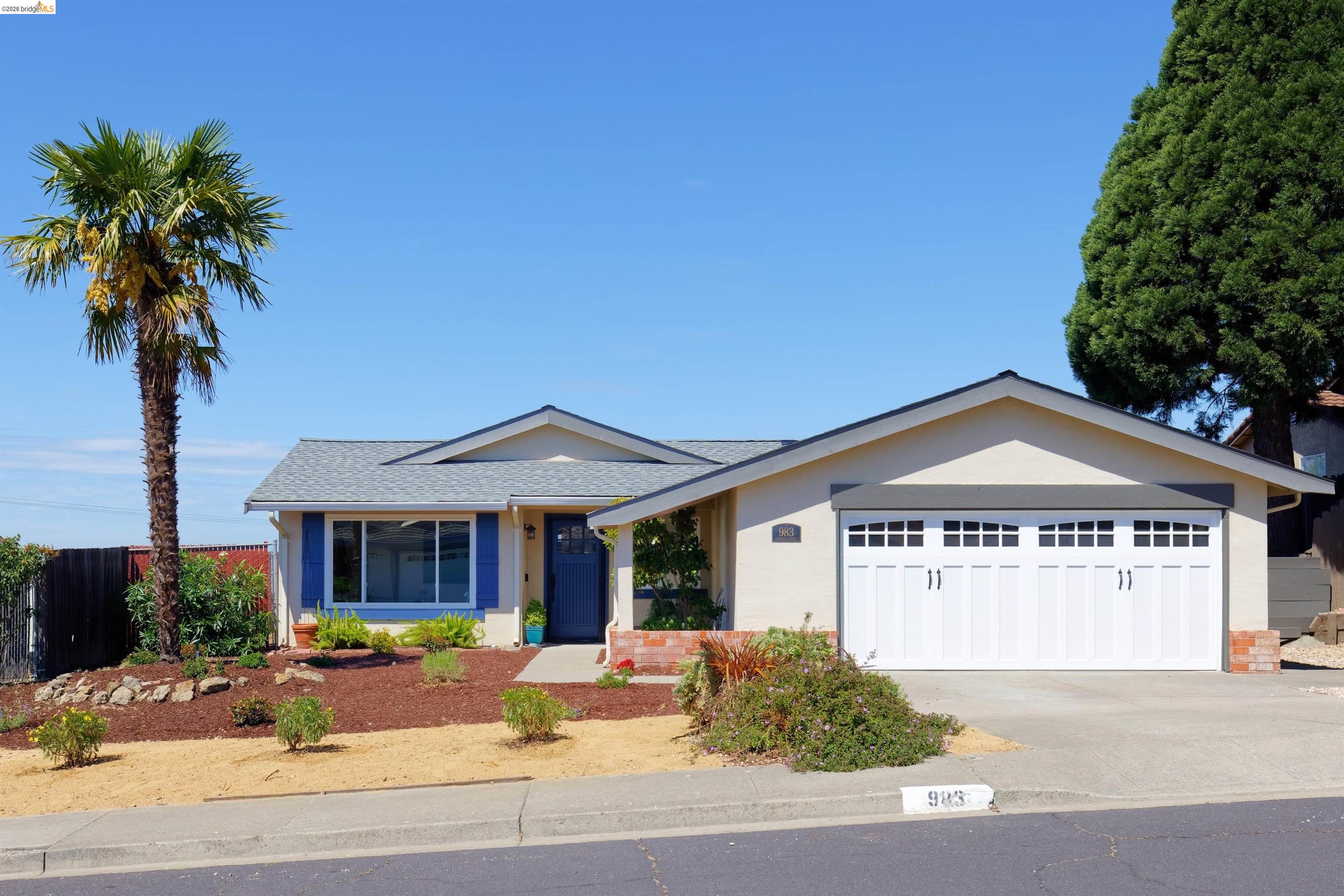 Single story home featuring a garage, concrete driveway, a shingled roof, and stucco siding