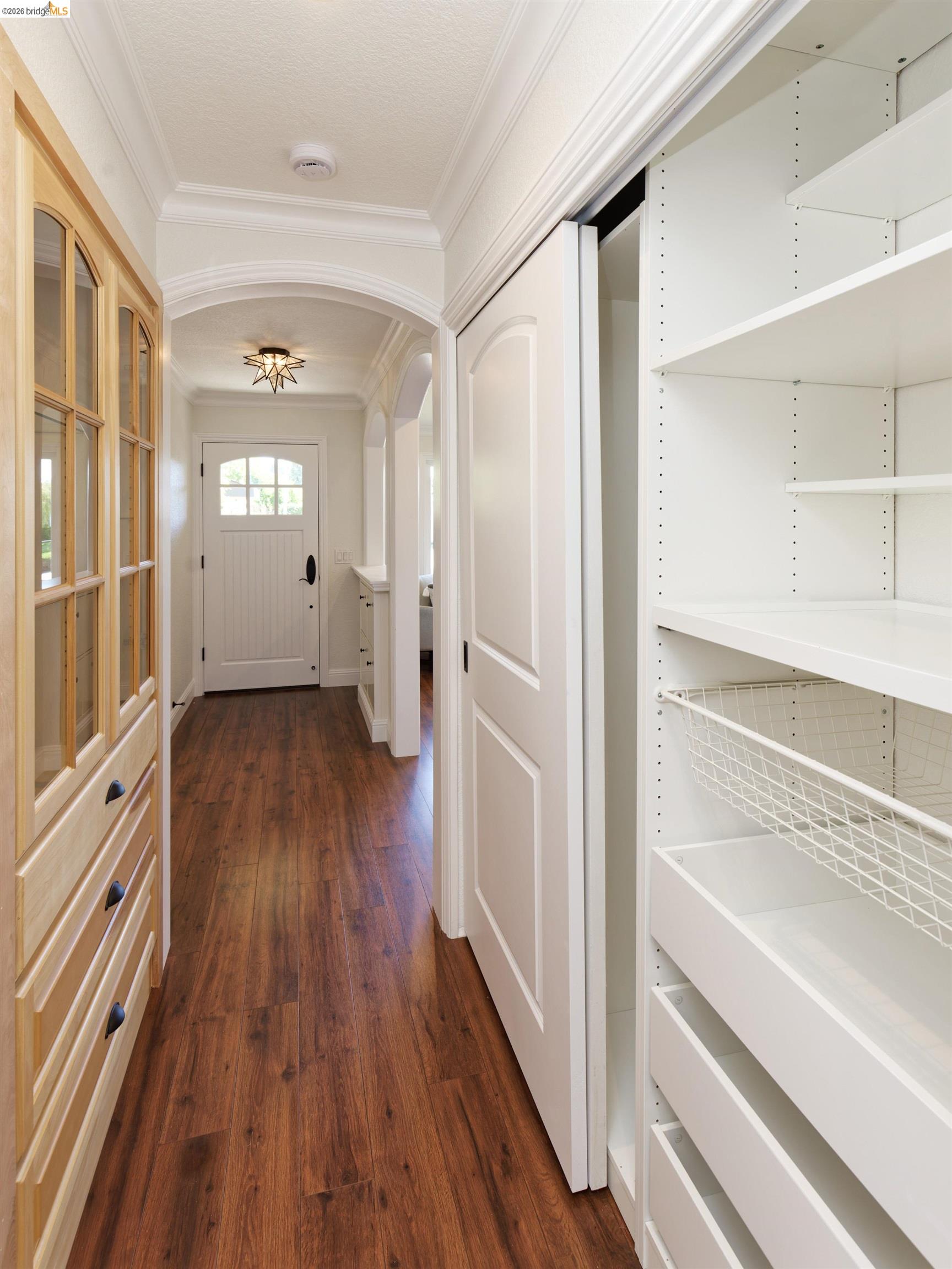 983 Seascape Circle Rodeo, CA 94572 - Photo 12 of 45 Hallway with arched walkways, dark wood-type flooring, and ornamental molding