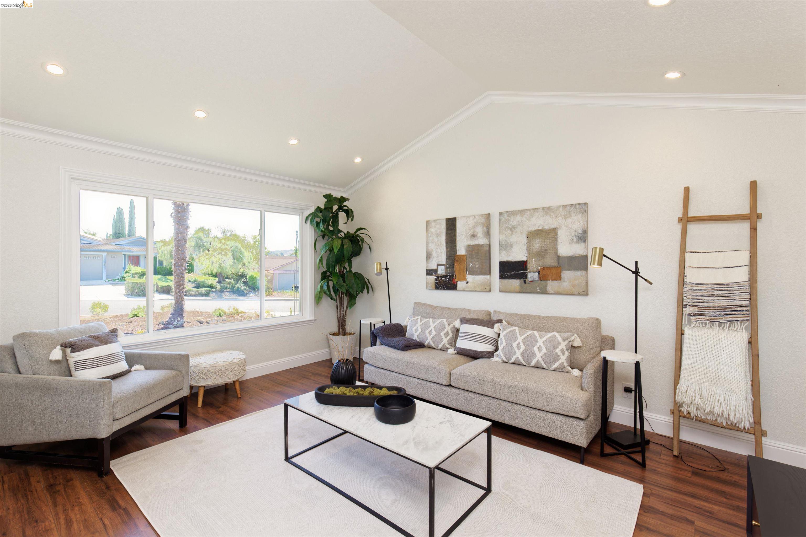 983 Seascape Circle Rodeo, CA 94572 - Photo 7 of 45 Living area with dark wood-style floors, recessed lighting, lofted ceiling, and ornamental molding