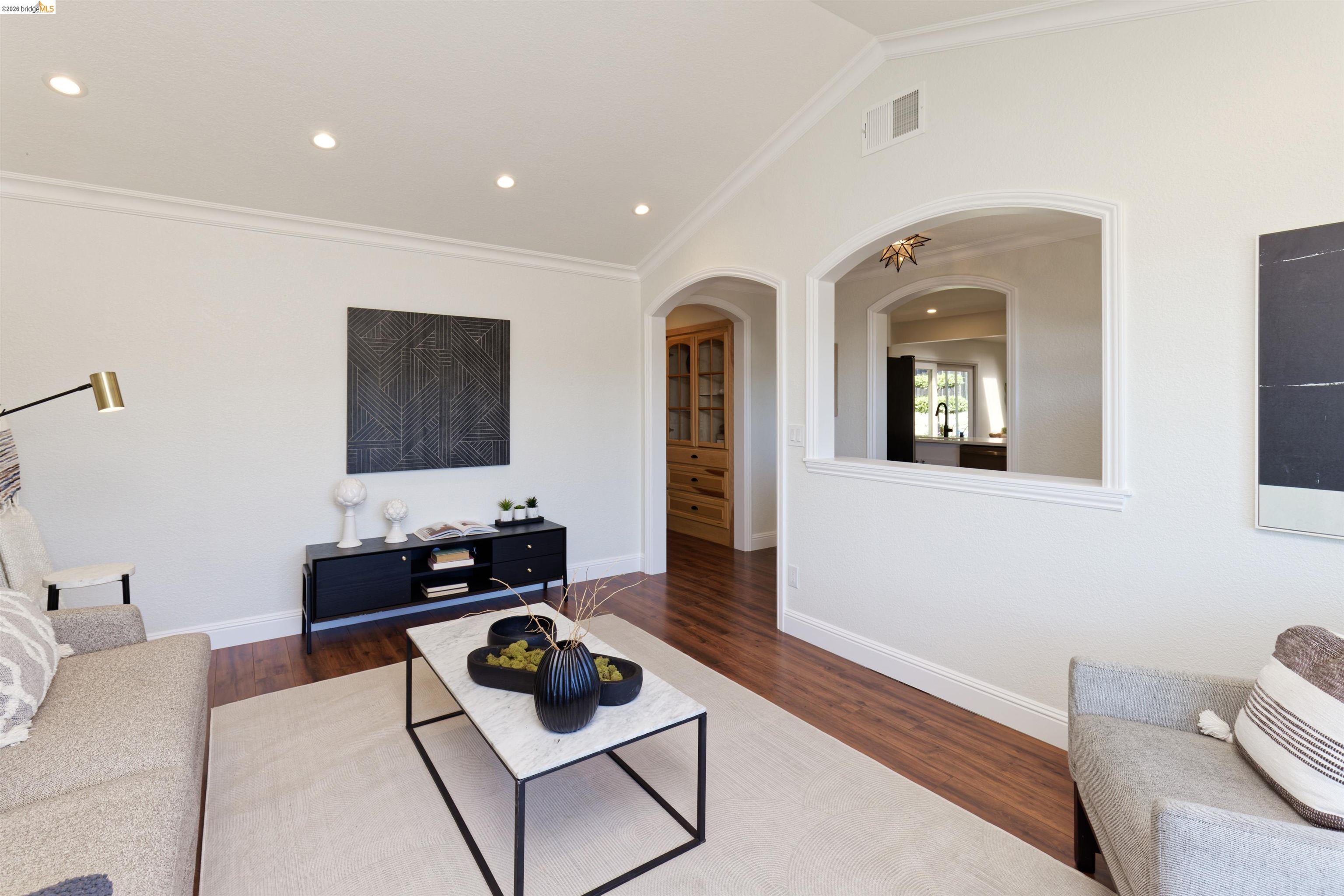 983 Seascape Circle Rodeo, CA 94572 - Photo 9 of 45 Living room with vaulted ceiling, dark wood finished floors, ornamental molding, recessed lighting, and arched walkways