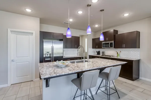 a bathroom with a granite countertop sink a toilet and a large mirror