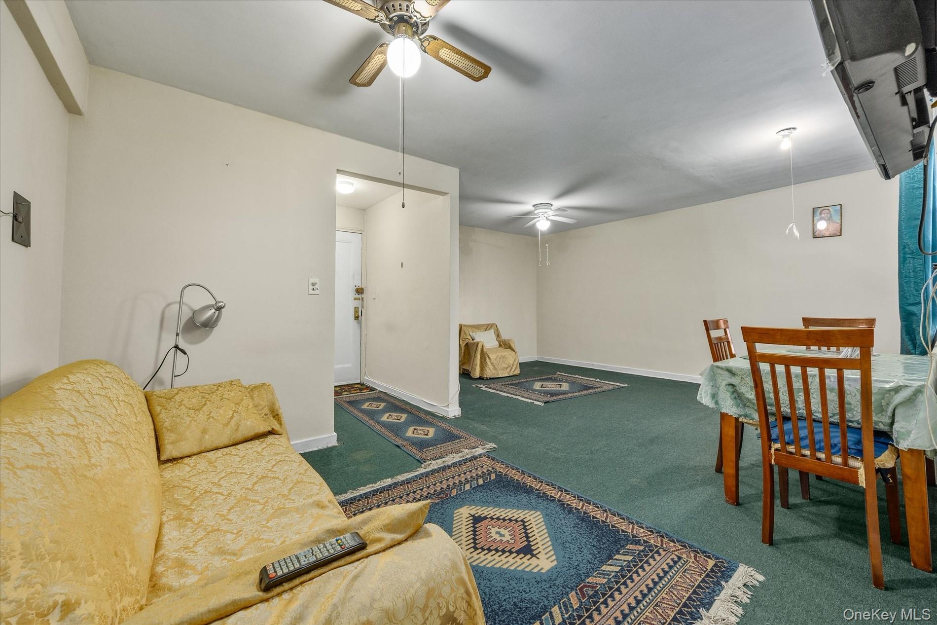52-35 39th Road, Unit 2C Queens, NY 11377 - Photo 3 of 10 Carpeted living room with ceiling fan
