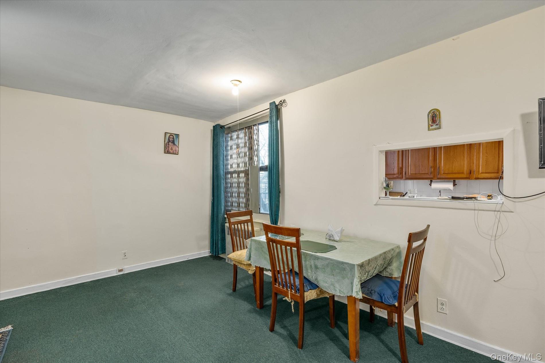52-35 39th Road, Unit 2C Queens, NY 11377 - Photo 4 of 10 Dining room with dark colored carpet and baseboards