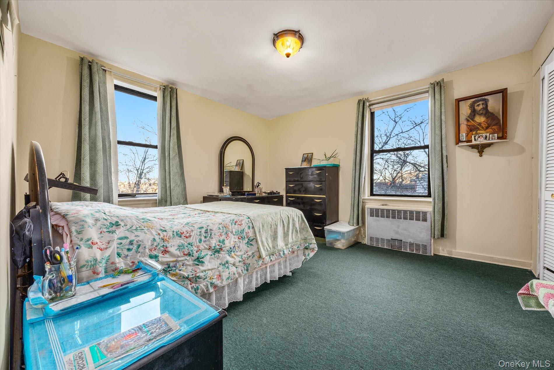 52-35 39th Road, Unit 2C Queens, NY 11377 - Photo 8 of 10 Carpeted bedroom with radiator heating unit and baseboards