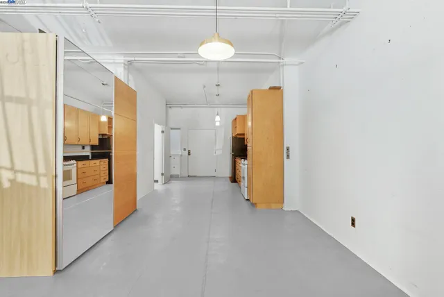 a view of a hallway with a refrigerator and a chandelier