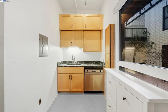 a kitchen with stainless steel appliances granite countertop a sink and a refrigerator
