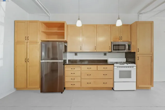 a kitchen with cabinets stainless steel appliances and a island