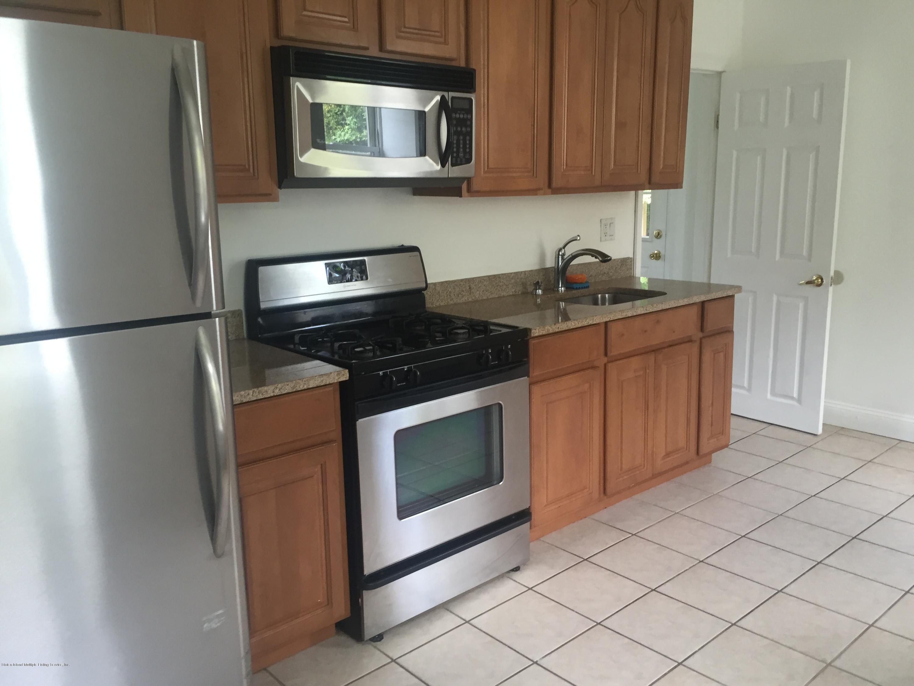 2703 Amboy Road Staten Island, NY 10306 - Photo 4 of 8 a kitchen with stainless steel appliances granite countertop a refrigerator a stove a sink and dishwasher