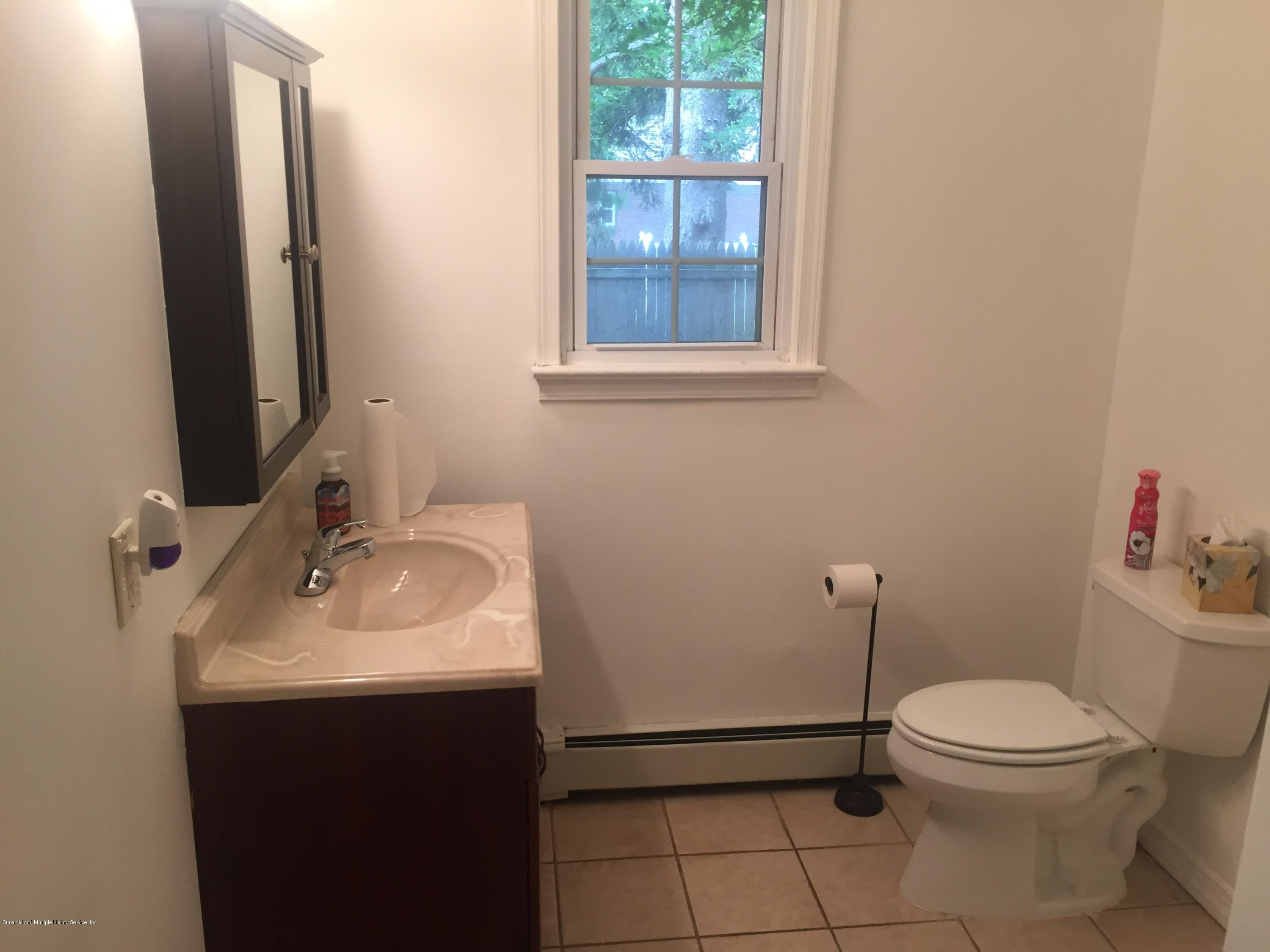 2703 Amboy Road Staten Island, NY 10306 - Photo 8 of 8 a bathroom with a toilet sink and mirror