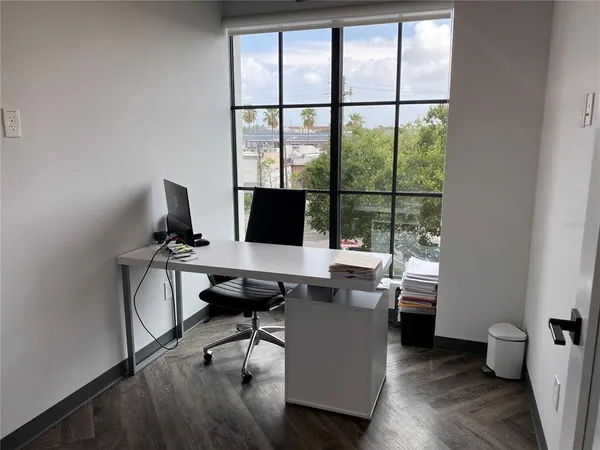 a view of a workspace with furniture and a window